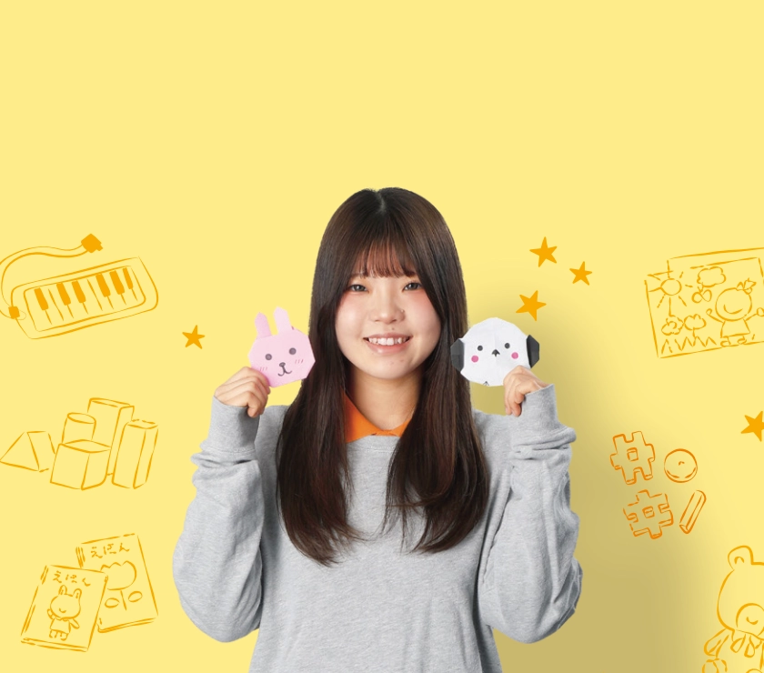 手作り人形を持つ幼児保育学科の学生