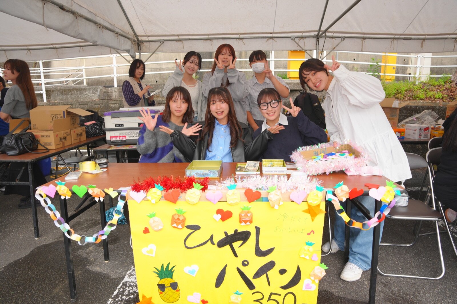 手づくりの装飾を施した模擬店と学生たち