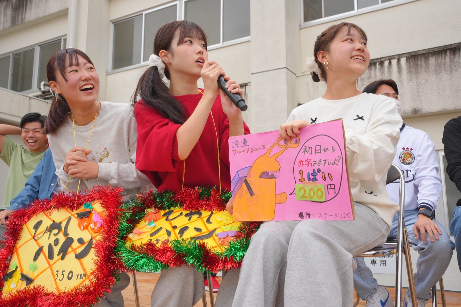 看板を掲げて来場者へ呼びかける学生