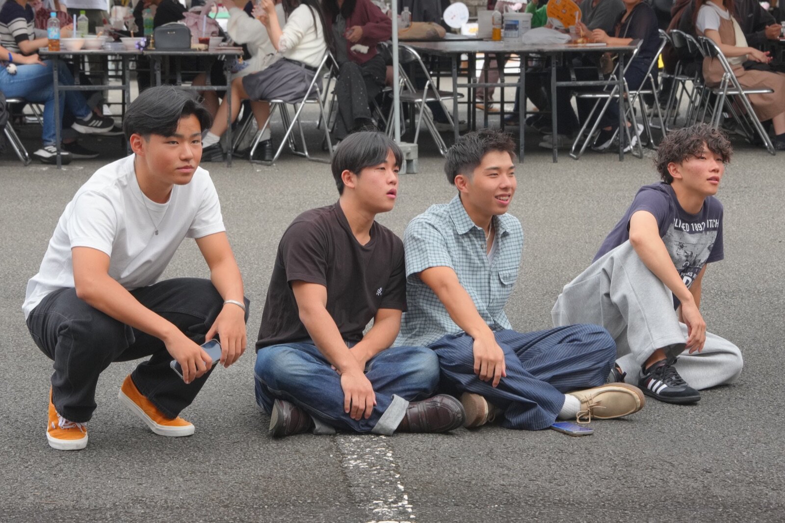 屋外ステージを見つめる学生たち