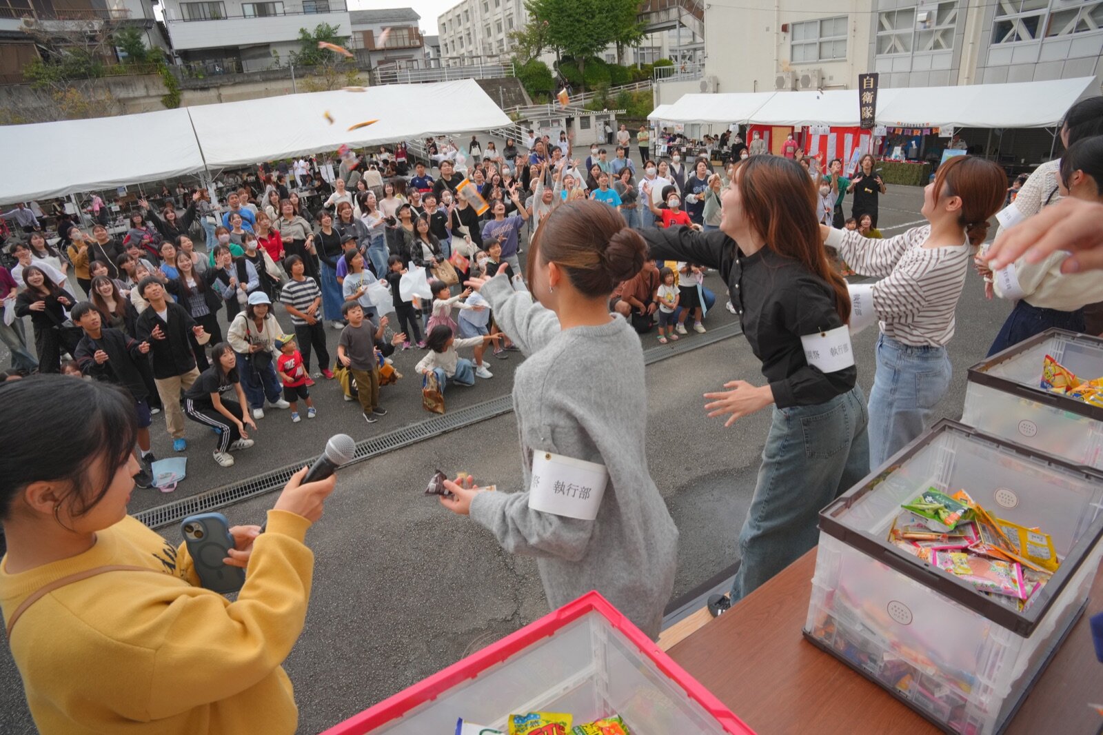 投げられたお菓子へ手を伸ばす来場者