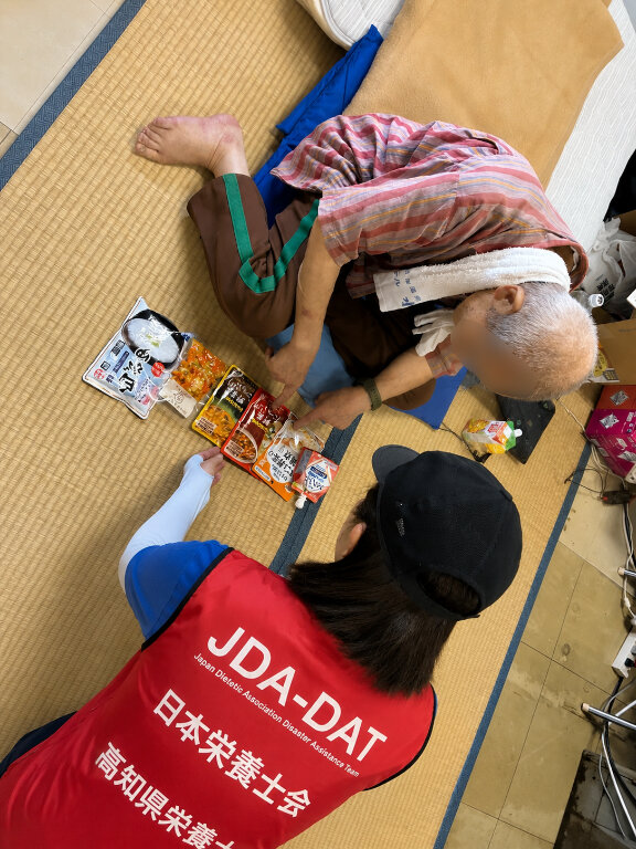 避難者と食品を確認しながら話す支援スタッフ