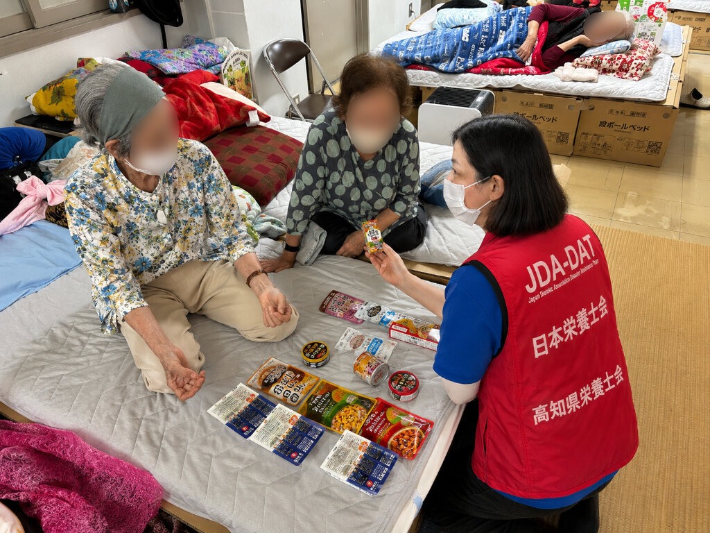 避難者に食品を見せながら説明する支援スタッフ