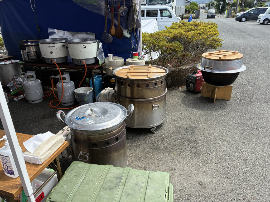 屋外に並ぶ炊き出し用の大きな釜と炊飯器
