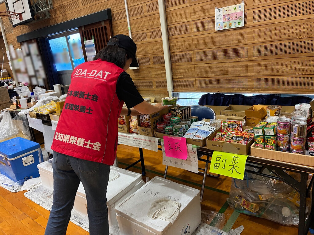 主食や副菜などに分けて並べられた支援食品を確認する様子